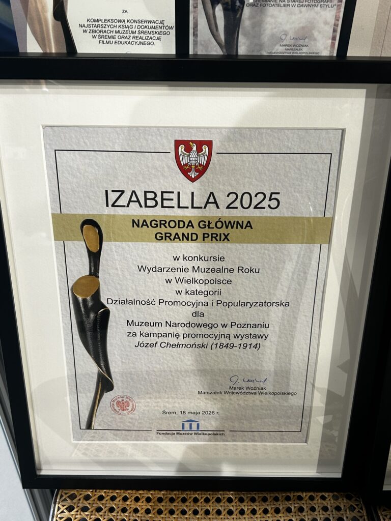 Dyplom oprawiony w czarną ramę. Na dyplomie napis: Izabella 2025. Nagroda główna. Grand Prix.